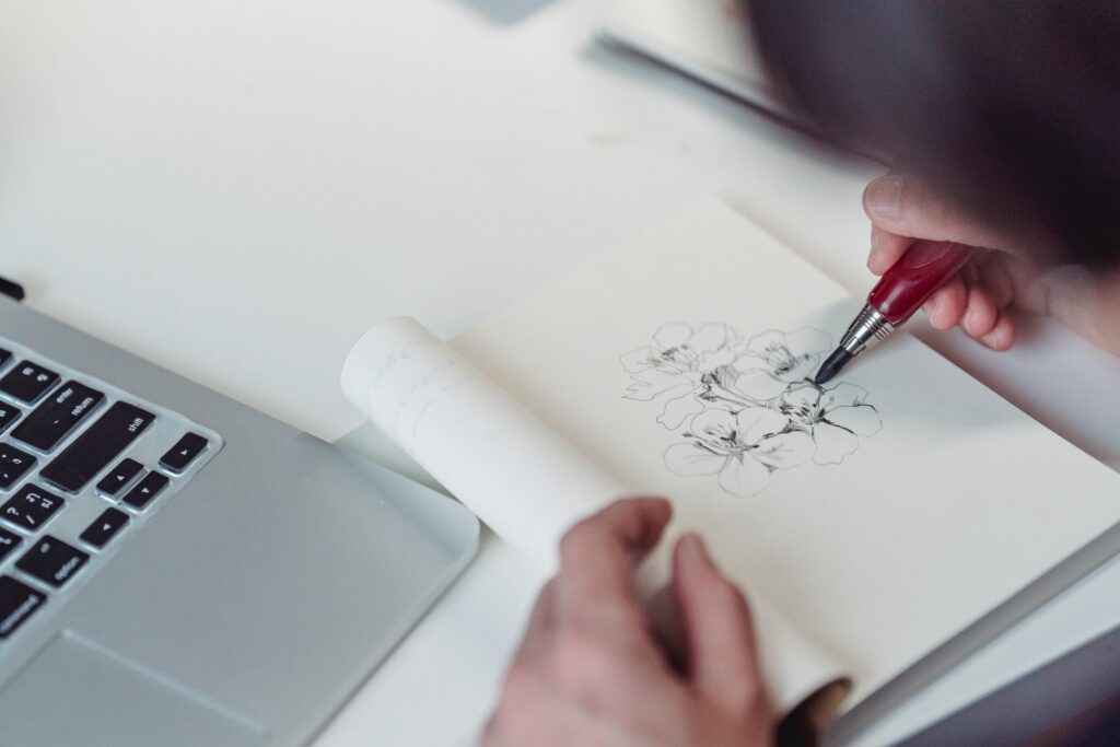 Personne entrain de dessiner un croquis de fleurs